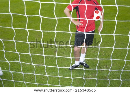 Soccer player standing at goal net
