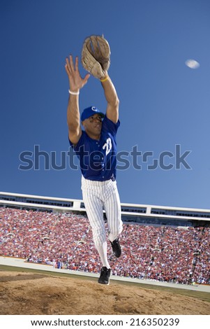 Baseball player reaching to catch baseball