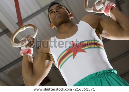 Male gymnast on gymnastic rings, low angle view