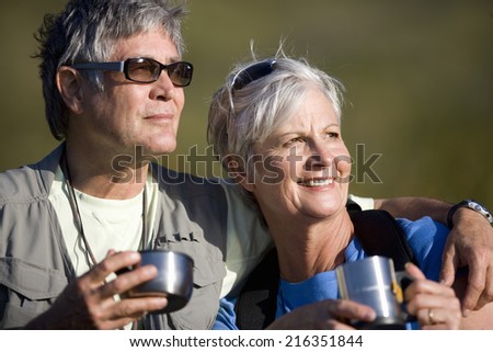 Senior couple drinking coffee from travel cups outdoors