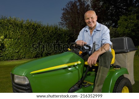 Senior man sitting on riding lawn mower