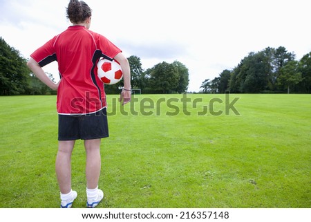 Soccer player with ball looking down field