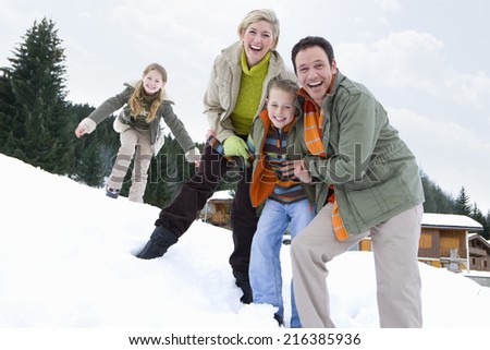 Portrait of young happy family standing in snow