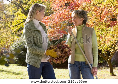 Mother and daughter doing yard work in autumn