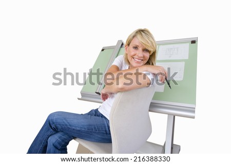 Woman sitting by blue prints on drafting board, smiling portrait, cut out
