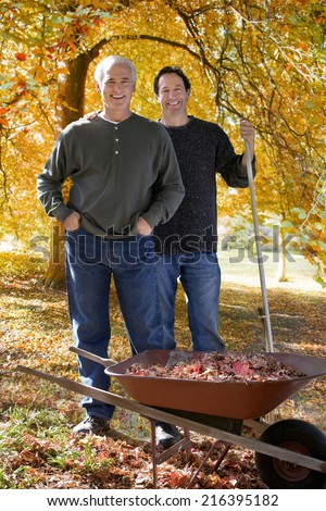 Men doing yard work together in autumn
