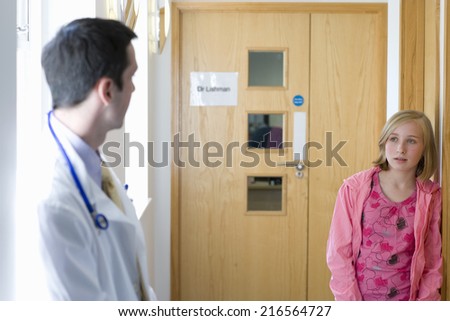 Worried girl looking at doctor in corridor