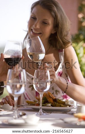 Couple toasting wine glasses at patio table