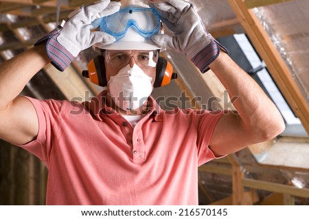 Construction worker wearing protective mask in attic