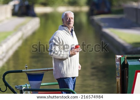 Man drinking coffee on boat in canal