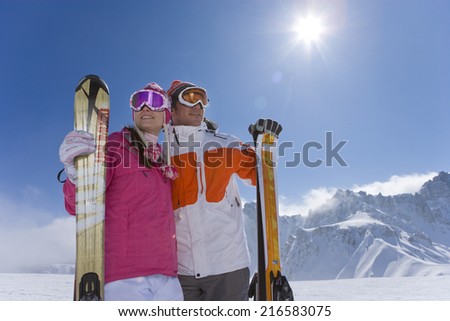 Skiers sitting on mountain top looking at mountains