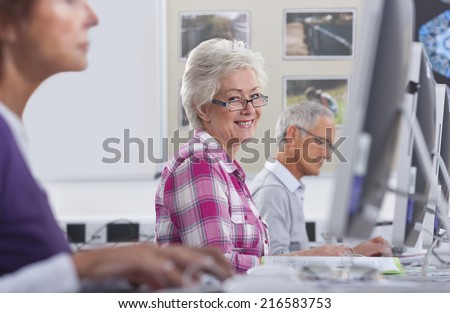 Smiling adult student studying in college evening class computer lab