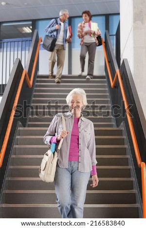 Adult students walking down stairs in college arriving for evening classes