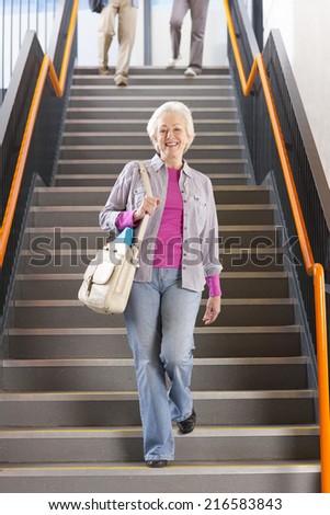 Adult students walking down stairs in college arriving for evening classes