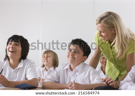 Teacher helping school boy in classroom