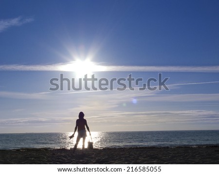 Woman standing on beach near tranquil ocean