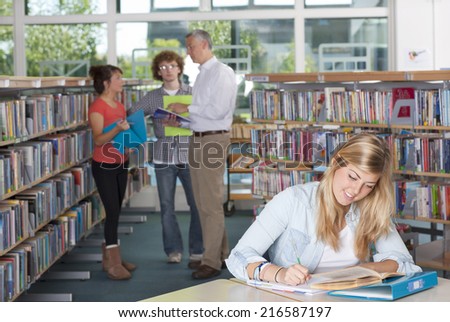 Teacher and students studying in school library
