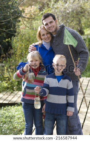 Family with bug net and specimen jars outdoors
