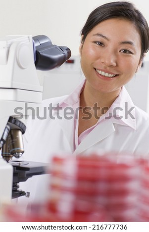 Technician working with microscope in laboratory