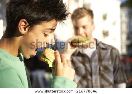 Boys eating burgers.