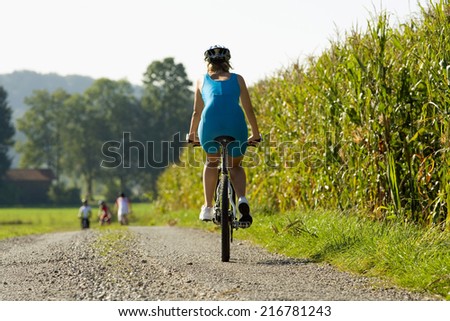 A woman on a cycle catching up with her friends in front.