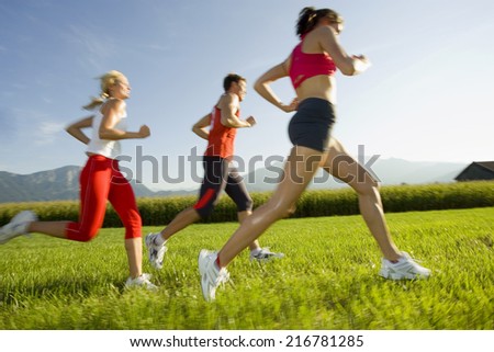 Two women and a man jogging.