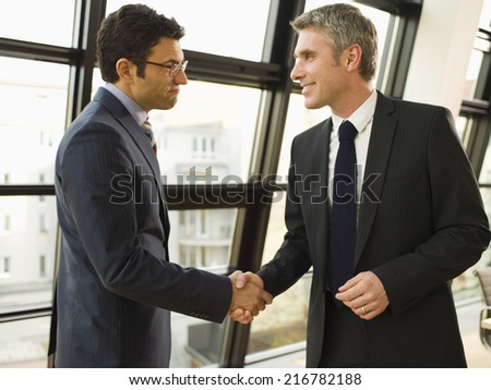 Two businessmen shake hands.