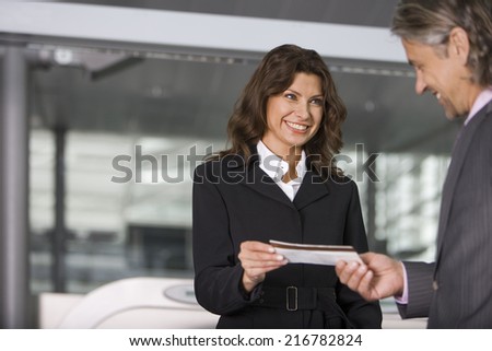 A businessman showing his boarding pass at the check in counter.