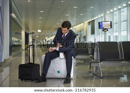 A businessman waiting in the departure lounge.