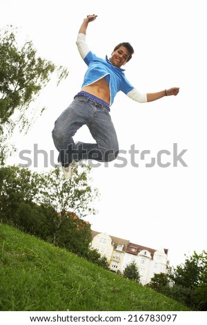 A boy jumping in a park.