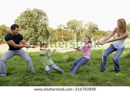 Father and son playing tug of war with mother and daughter.