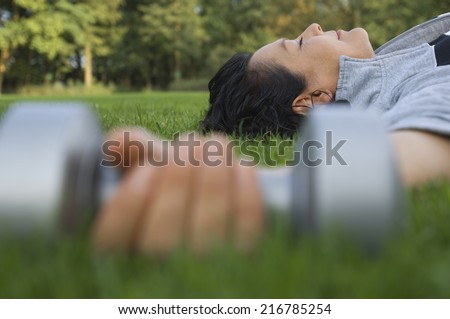 A woman lying down after lifting dumbbells