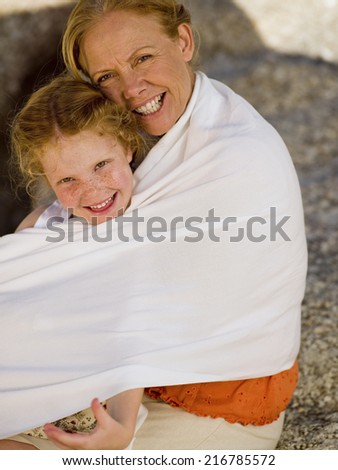 A grandmother hugging her granddaughter.