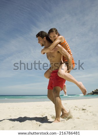 Man carrying girlfriend on back.