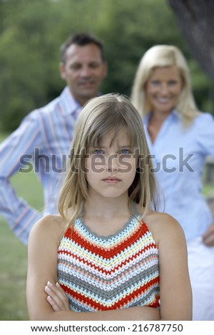A girl looking upset from her parents.