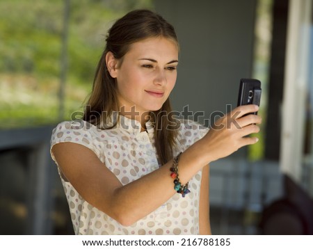 A woman taking pictures from her camera phone.