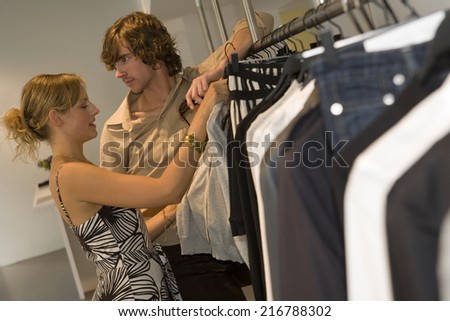 A couple looking at clothes in a boutique.