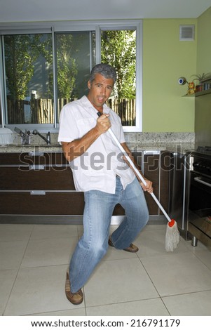 Man mopping the kitchen floor.
