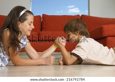 Siblings arm wrestling.