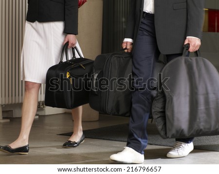 Couple carrying their luggage in a hotel.