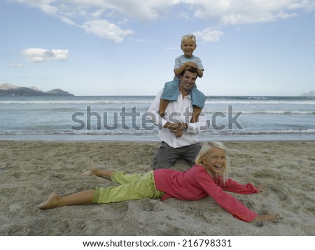 Mid adult man playing with his children on the beach
