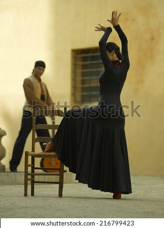 Side profile of a female dancer dancing with a young man holding a guitar in the background
