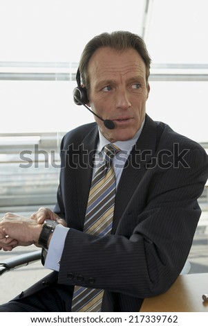 Close-up of a businessman wearing headset and checking the time