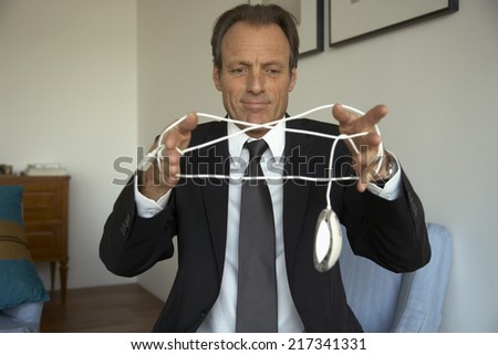 Mature man tangled in a computer mouse wire
