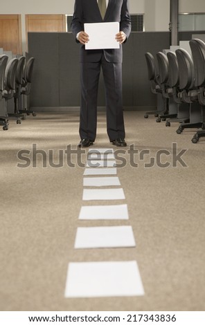 Low section view of a businessman holding a paper