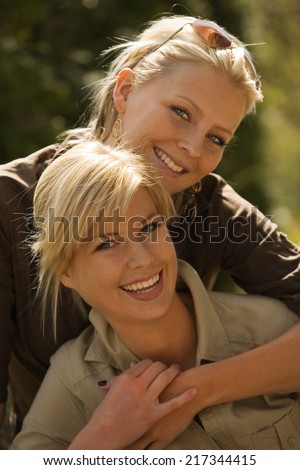 Portrait of a young woman hugging another young woman from behind