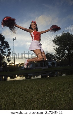 Low angle view of a cheerleader jumping and smiling