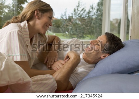 Couple in bed together laughing