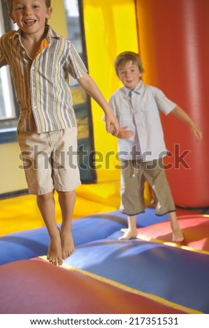 Two boys jumping on an inflatable bouncy castle