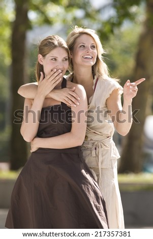 Happy women looking into distance pointing with shocked expression